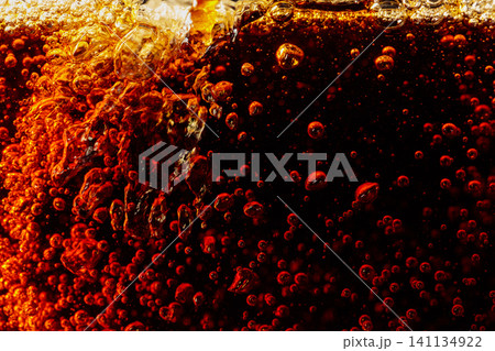 Carbonated drink is poured into a glass. 141134922