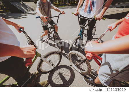 Bmx riders performing tricks at skatepark. 141135069