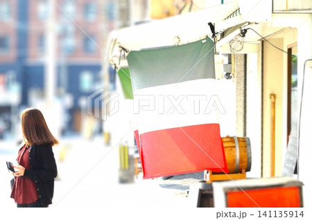 ヨーロッパ風の街なみで振り返る若い女性 ヨーロッパ風の街なみで振り返る若い女性 141135914