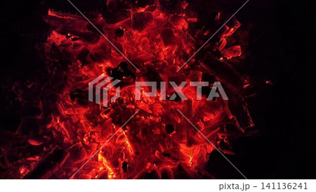 Close up of glowing charcoal embers burning with red and orange tones at night. Soft heat and shimmering texture create magical atmosphere. Warm abstract scene symbolizing warmth and quiet at nature Close up of glowing charcoal embers burning with red and orange tones at night. Soft heat and shimmering texture create magical atmosphere. Warm abstract scene symbolizing warmth and quiet at nature 141136241
