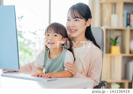 リビングで仕事をするママと遊ぶこども リビングで仕事をするママと遊ぶこども 141136419