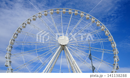 Close-up of the ferris wheel spinning and the blue sky as a background 141138288