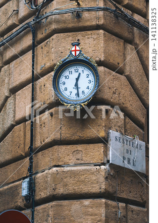 GENOA, ITALY - NOVEMBER 04, 2018 - Clocks on the facade of the house on the narrow streets of the city GENOA, ITALY - NOVEMBER 04, 2018 - Clocks on the facade of the house on the narrow streets of the city 141138325