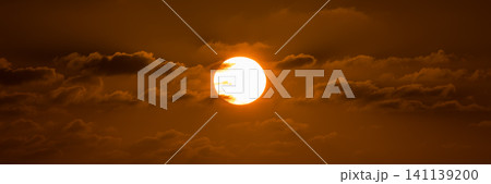Beatiful sunset above the mediterranean sea. Sunrise with red and orange skies and the sun shining. Bright sun with dark background 141139200