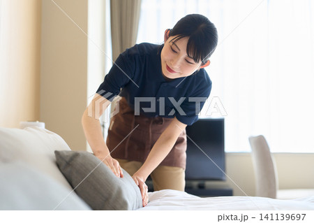 客室のベッドメイキングをする清掃業の女性 141139697