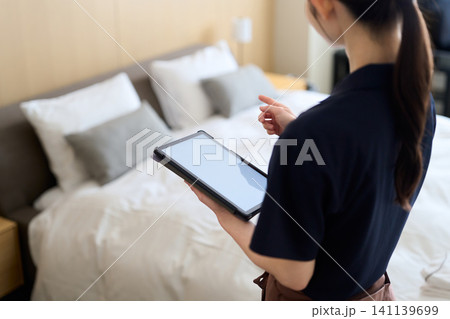 タブレットで仕事を管理する清掃業の女性 タブレットで仕事を管理する清掃業の女性 141139699