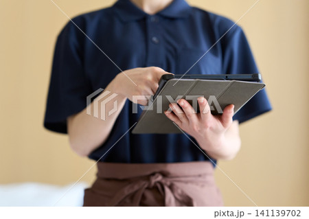 タブレットで仕事を管理する清掃業の女性 タブレットで仕事を管理する清掃業の女性 141139702