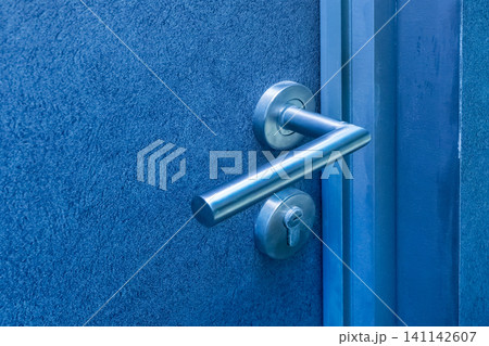 Steel doorknob opening or closing the entrance or exit of the house, close-up 141142607