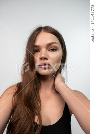 Young woman confidently posing for a beauty portrait, showcasing radiant skin and elegant style Young woman confidently posing for a beauty portrait, showcasing radiant skin and elegant style 141142772