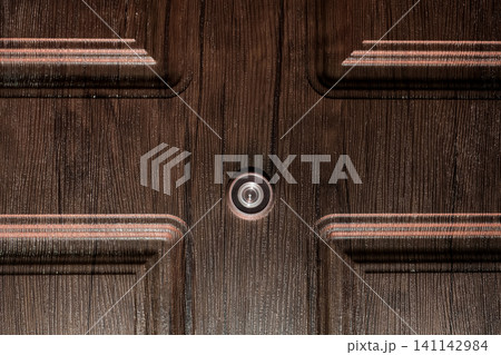 Peephole brown door eye look hole from spy security, safety close-up 141142984