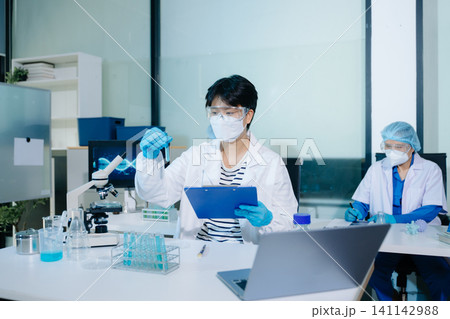 A professional uses biometric fingerprint scanning on a digital tablet in a high-tech lab, representing secure data access and innovation in biotechnology A professional uses biometric fingerprint scanning on a digital tablet in a high-tech lab, representing secure data access and innovation in biotechnology 141142988