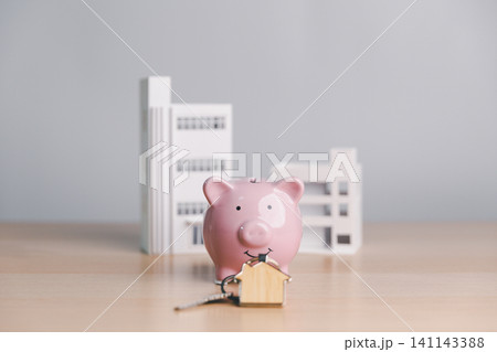 Pink piggy bank with house key and modern building models, symbolizing property ownership, real estate savings, mortgage deposit, home buying, and investment planning. Pink piggy bank with house key and modern building models, symbolizing property ownership, real estate savings, mortgage deposit, home buying, and investment planning. 141143388