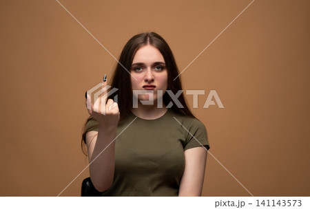 Young woman showing middle finger gesture, expressing anger and disapproval with a defiant facial expression Young woman showing middle finger gesture, expressing anger and disapproval with a defiant facial expression 141143573