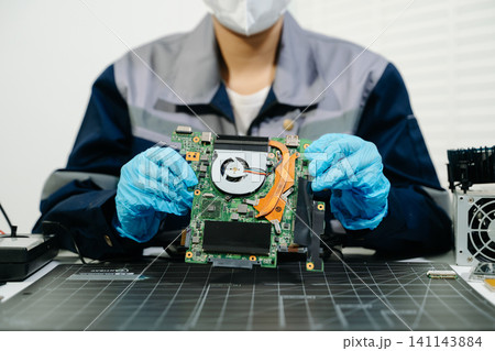 Electronics Technician Soldering Laptop Motherboard Circuit in Workshop Electronics Technician Soldering Laptop Motherboard Circuit in Workshop 141143884