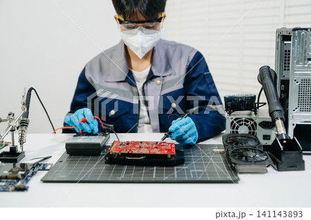 Professional technician repairing a graphics card PCB using soldering equipment. Ideal for technology, electronics repair, engineering and IT service concepts. Professional technician repairing a graphics card PCB using soldering equipment. Ideal for technology, electronics repair, engineering and IT service concepts. 141143893