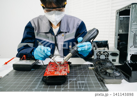 Professional technician repairing a graphics card PCB using soldering equipment. Ideal for technology, electronics repair, engineering and IT service concepts. Professional technician repairing a graphics card PCB using soldering equipment. Ideal for technology, electronics repair, engineering and IT service concepts. 141143898