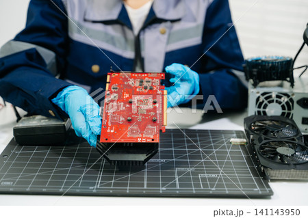 Professional technician repairing a graphics card PCB using soldering equipment. Ideal for technology, electronics repair, engineering and IT service concepts. Professional technician repairing a graphics card PCB using soldering equipment. Ideal for technology, electronics repair, engineering and IT service concepts. 141143950