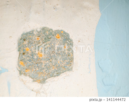 Abstract background of a weathered and distressed wall with peeling paint and plaster in faded light blue and beige tones, showcasing aged texture and grunge details. Abstract background of a weathered and distressed wall with peeling paint and plaster in faded light blue and beige tones, showcasing aged texture and grunge details. 141144472