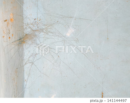 Abstract background of a weathered and distressed wall with peeling paint and plaster in faded light blue and beige tones, showcasing aged texture and grunge details. Abstract background of a weathered and distressed wall with peeling paint and plaster in faded light blue and beige tones, showcasing aged texture and grunge details. 141144497