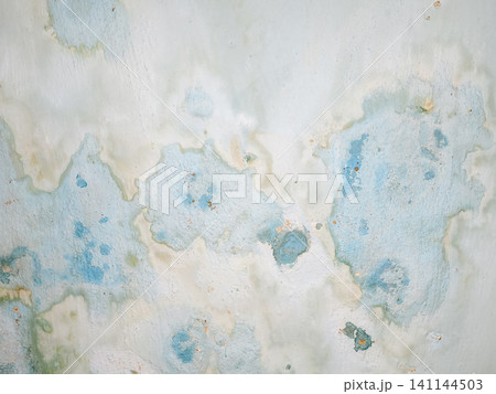 Abstract background of a weathered and distressed wall with peeling paint and plaster in faded light blue and beige tones, showcasing aged texture and grunge details. Abstract background of a weathered and distressed wall with peeling paint and plaster in faded light blue and beige tones, showcasing aged texture and grunge details. 141144503