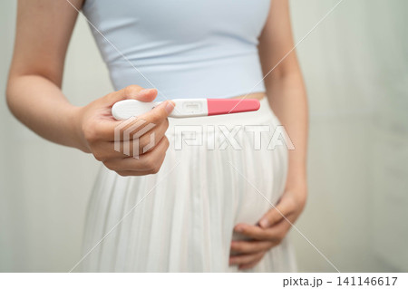 Asian holding pregnancy test for female of ovulation day, fetus, maternity, childbirth, birth control. 141146617
