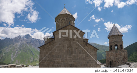 Ancient Gergeti Trinity Church against Caucasus mountains in Georgia with copy space Ancient Gergeti Trinity Church against Caucasus mountains in Georgia with copy space 141147034