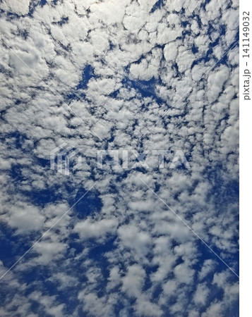 A scenic view of the blue sky filled with beautiful textured altocumulus clouds. A scenic view of the blue sky filled with beautiful textured altocumulus clouds. 141149032
