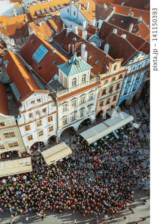 High angle view of historic buildings and crowds in Prague's center. High angle view of historic buildings and crowds in Prague's center. 141150393