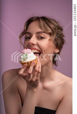Woman feeling pleasure eating a sweet pastry. A dessert concept, showing indulgence and happiness with a snack Woman feeling pleasure eating a sweet pastry. A dessert concept, showing indulgence and happiness with a snack 141150865