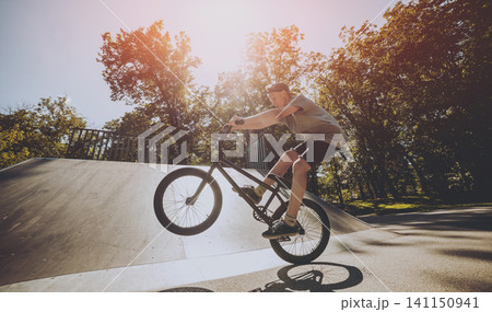 Bmx rider performing tricks at skatepark. Bmx rider performing tricks at skatepark. 141150941