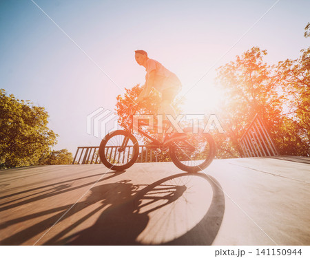 Bmx rider performing tricks at skatepark. Bmx rider performing tricks at skatepark. 141150944
