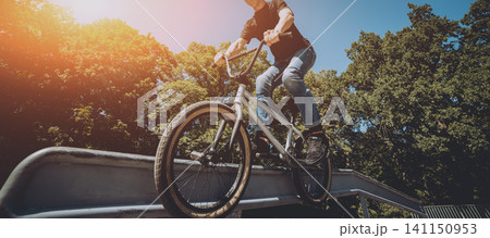Bmx rider performing tricks at skatepark. 141150953