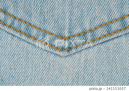 Light blue denim jeans pocket with yellow stitching close up. Detailed texture of cotton fabric surface. Background pattern for fashion industry and casual apparel design concept Light blue denim jeans pocket with yellow stitching close up. Detailed texture of cotton fabric surface. Background pattern for fashion industry and casual apparel design concept 141151057