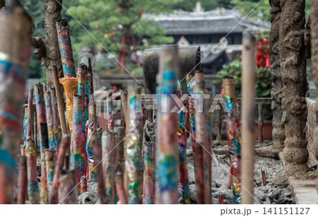 Coils of fragrant smoke gently ascend from highly ornate, colorful joss sticks, casting a serene veil of devotion over the ancient, shadowed pavilions resting in the quiet distance. Coils of fragrant smoke gently ascend from highly ornate, colorful joss sticks, casting a serene veil of devotion over the ancient, shadowed pavilions resting in the quiet distance. 141151127