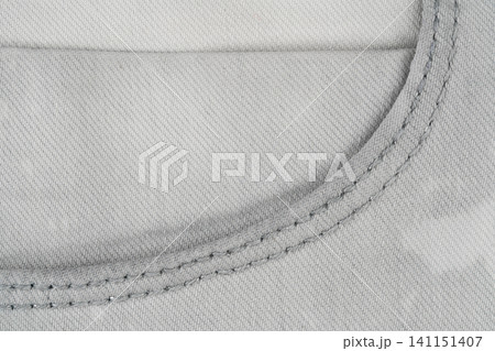 Gray denim fabric texture with visible stitching detail top view Gray denim fabric texture with visible stitching detail top view 141151407