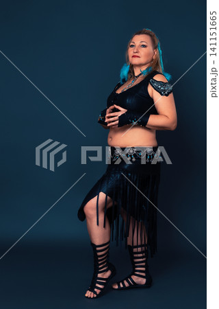 Full length portrait of woman in black handmade leather outfit - performance costume crafted by hand Full length portrait of woman in black handmade leather outfit - performance costume crafted by hand 141151665