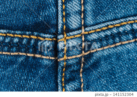 Closeup denim fabric with yellow stitching detail Closeup denim fabric with yellow stitching detail 141152304