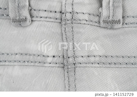 Denim fabric texture with detailed stitching and buttonholes top view Denim fabric texture with detailed stitching and buttonholes top view 141152729