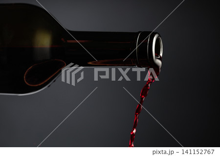 Red wine pours out of the bottle. Red wine pours out of the bottle. 141152767