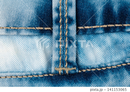 Macro detail of blue denim jeans textile. Close up of garment fabric with textured pattern, stitching and seam. Casual clothing material background, fashion industry design element 141153065
