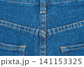 Blue jeans back pocket and yoke seam detail. Denim fabric texture background with yellow stitching 141153325