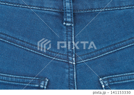 Close up of blue denim jeans fabric with seams and belt loop 141153330