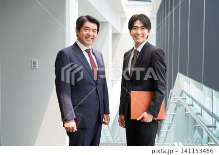 笑顔で立つ2人のビジネスパーソン 笑顔で立つ2人のビジネスパーソン 141153486