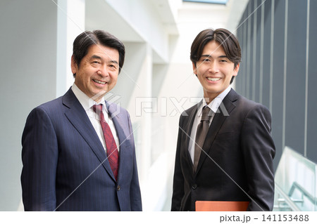 笑顔で立つ2人のビジネスパーソン 笑顔で立つ2人のビジネスパーソン 141153488