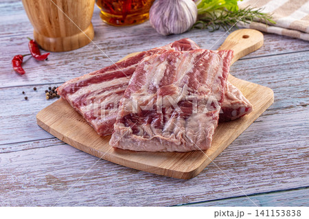 Raw pork spare ribs with seasonings on a rustic wooden table 141153838