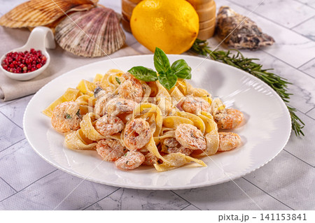 Shrimp pasta with creamy sauce and fresh basil on white plate Shrimp pasta with creamy sauce and fresh basil on white plate 141153841