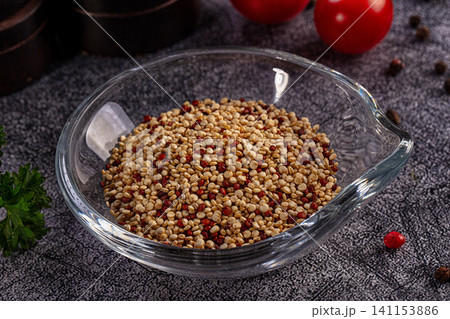 Raw quinoa grains in glass bowl on dark stone background Raw quinoa grains in glass bowl on dark stone background 141153886