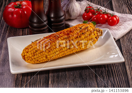 Grilled corn cob with spices on white plate 141153896