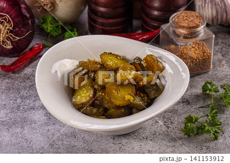 Pickled cucumber slices in white ceramic bowl with spices 141153912