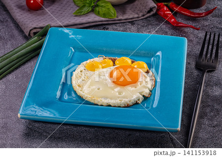 Fried egg shaped like paw print on blue square plate with vegetables 141153918